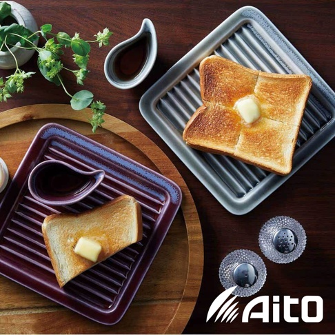 美濃燒素釉吐司酥脆專用盤，一個為深紫紅色，一個為淺灰色，兩者皆有烤盤紋路及醬料碟，盤中各放有塗抹奶油的吐司。