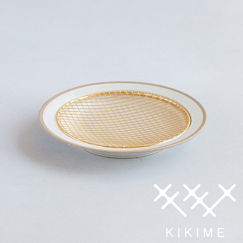 美濃燒圓形餐盤，盤身為白色，邊緣帶有淺褐色釉，中央置有一個金色網狀濾網。