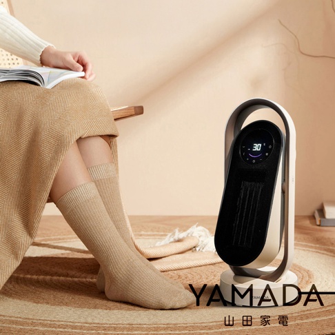 模式B： 一個配備數字顯示屏的白色和黑色立式陶瓷加熱器，放在圓形棕色地毯上，旁邊是一位坐在椅子上，身穿米色裙子和長襪的女士。