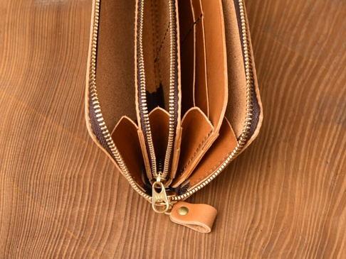 職人手作皮夾，棕色皮革材質，內有雙拉鍊設計，呈現多個卡槽與分隔空間，金屬拉鍊與拉頭。