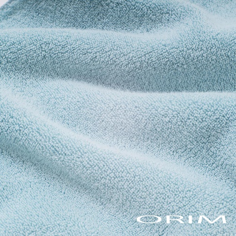 淺藍色毛巾，柔軟蓬鬆的毛圈材質，觸感細緻，適合包裹頭髮，具有良好的吸水性。