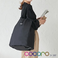 黑色簡約輕巧折疊購物車，採用耐用布料製成，側面有品牌標籤，下方配有輪子，方便攜帶。