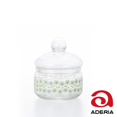 昭和復古風格的透明玻璃儲物罐，罐身帶有白色花瓣和綠色花心的可愛小花圖案，配有圓形把手的玻璃蓋。