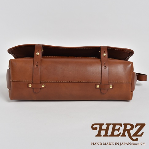 職人手作皮革復古郵差包，採用棕色全粒面皮革，設計簡約，有兩個搭扣和可調節的皮帶，整體風格古典耐用。