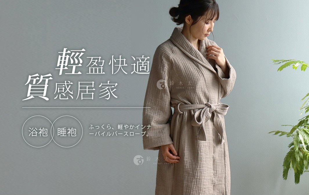 一位女性穿著米色雙面紗布立體織紋輕質浴袍/睡袍，腰間繫著同材質的腰帶。