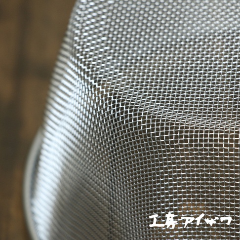 不鏽鋼網篩近拍，顯示細密的金屬網格紋理，網篩邊緣有部分反光。