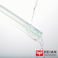 透明的家具防倒固定墊，帶有綠色條紋，表面有水流過，呈現濕潤狀態。