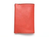 橘紅色皮革翻蓋記事本書套，有手工縫線細節。