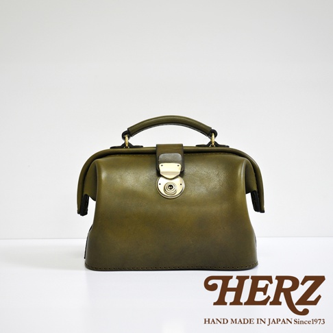 職人手作皮革方型迷你醫生包，橄欖綠色，具有金色金屬旋轉鎖扣和提把，簡約設計。