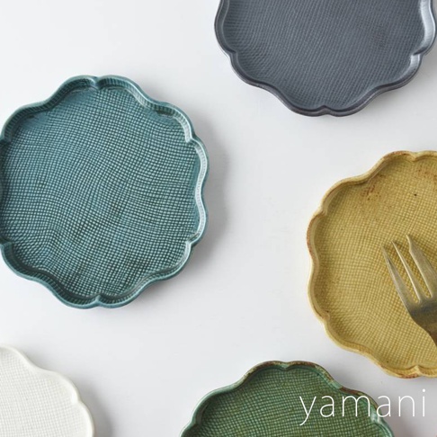 五個美濃燒花型甜點盤，分別為灰藍色、青綠色、黃色、綠色和白色，皆有重複交織的紋理，散落在白色背景上。