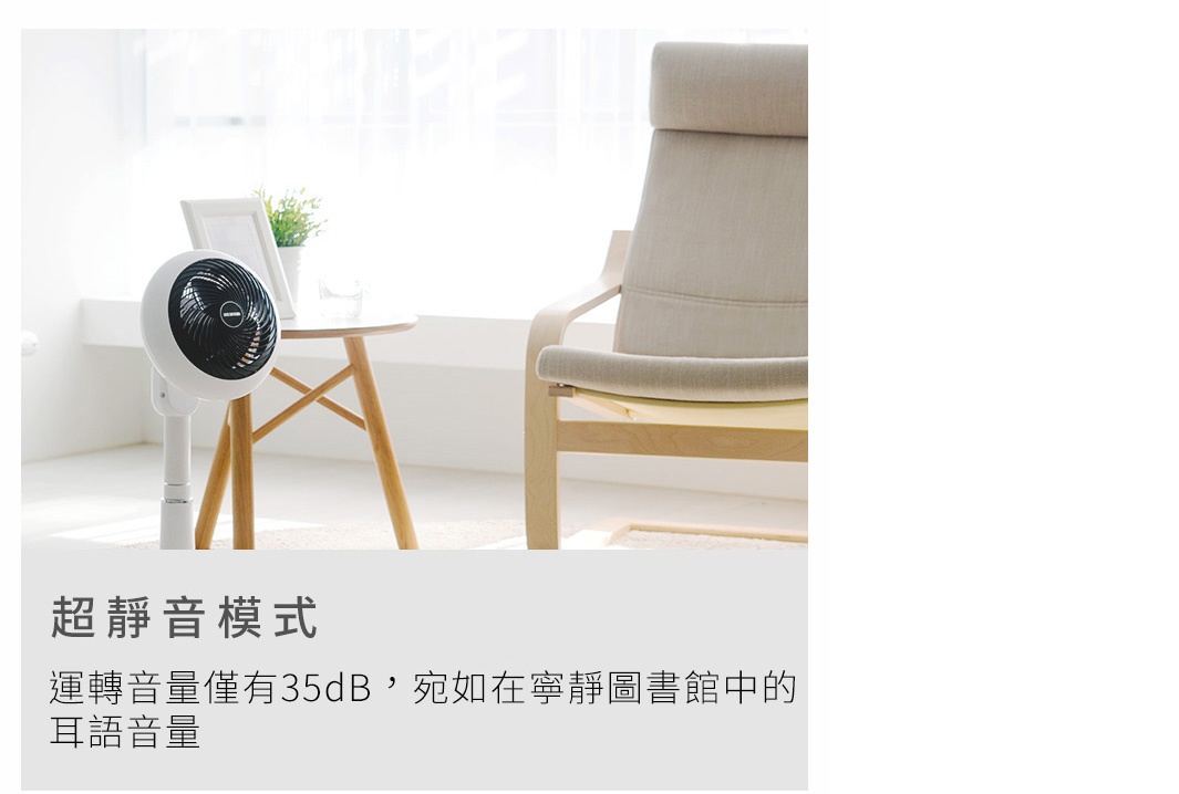 白色直立式循環扇，黑色扇葉網罩，擺放在木質地板上，旁邊有圓形木桌和米色布藝沙發，室內光線明亮。