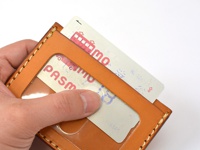 職人手作皮革橫式票券收納夾，採用天然棕色皮革，以手工縫線製作，設有透明視窗，可見夾層內置放的票券，展示產品的精緻工藝與材質。