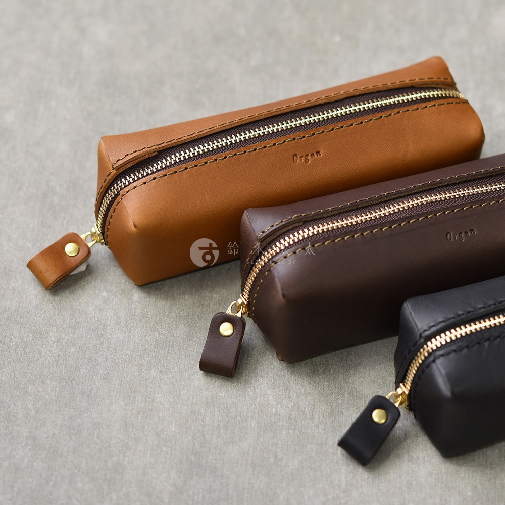 三款職人手作皮革Organ箱型收納筆袋，顏色分別為棕色、深棕色及黑色。筆袋採用光滑皮革材質，搭配金色拉鍊和同色系皮革拉環，整體設計簡潔大方。