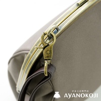 京都口金包品牌 AYANOKOJI 的古董金色金屬扣環與深棕色皮革背帶細節
