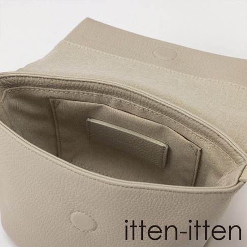 itten-itten 品牌標誌出現在一個淺灰色的皮革迷你單肩包內部，包包內側有一個織布內襯口袋，整體呈現精緻的皮革紋理。