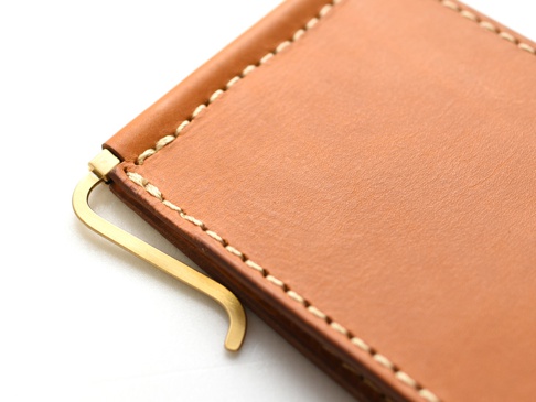 職人手作皮革橫式對折兩用收納短夾，以淺棕色皮革製成，配有金色金屬夾，呈現簡約實用的設計。