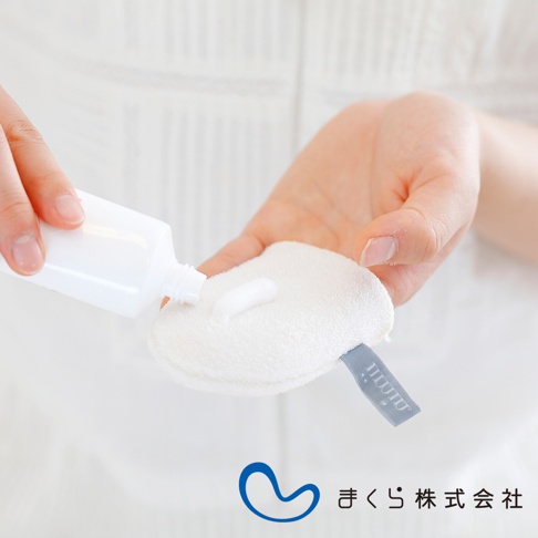 白色的 iimin 蠶絲洗臉手套，質地柔軟，上面擠有白色洗面乳。手套一角縫有淺灰色品牌標籤。