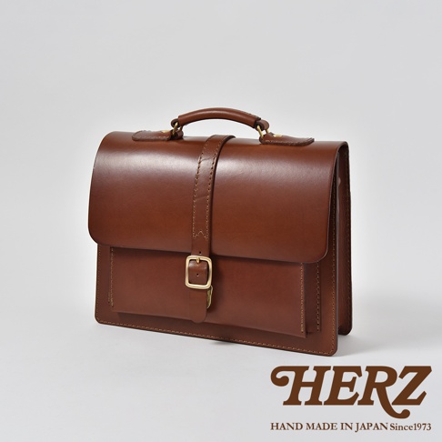 職人手作皮革三用單扣商務後背包，採用經典棕色皮革，設計簡約，配有單一金屬扣環，適合商務場合。