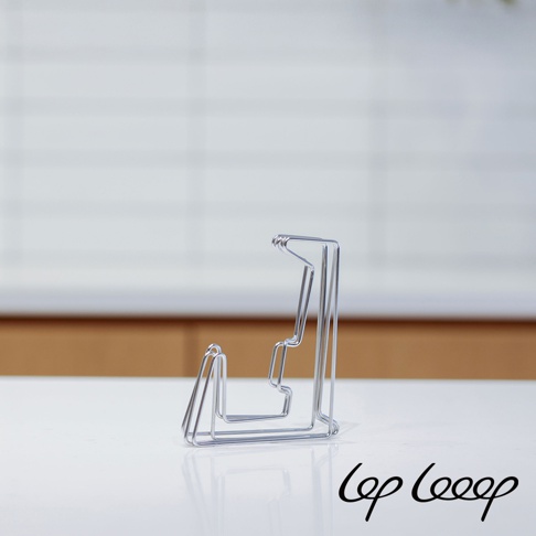 銀色金屬線條構成的伸縮式砧板架，設計簡約，線條流暢，呈現出金屬光澤。