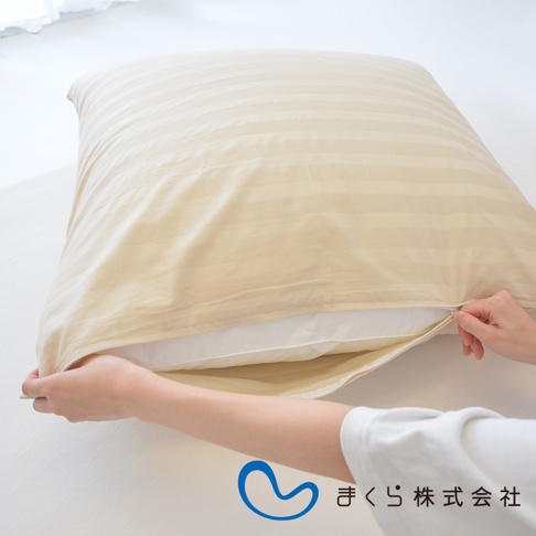 米色條紋枕套，拉開拉鍊，露出白色枕芯。