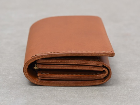 職人手作皮革Organ雙折迷你短夾，呈現溫潤的棕褐色，由光滑皮革製成，縫線整齊，側面可見多層卡槽設計。