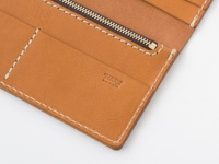 職人手作皮革簡約輕薄扁長夾，採用棕色牛皮材質，內部有拉鍊隔層、多個卡槽和縫線細節。