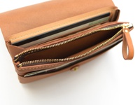 棕色皮革製長夾，內含多個隔層，可收納護照、機票和卡片，配有黃銅色拉鍊及皮革拉環。