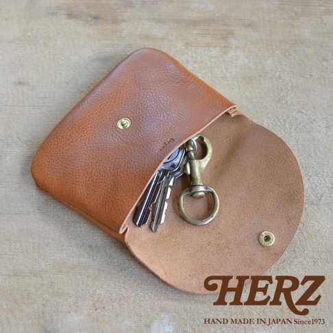 淺棕色皮革製成、附有鈕扣的鑰匙包，內有數把銀色鑰匙和一個黃銅色鑰匙圈。