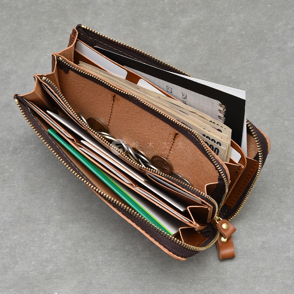 職人手作皮革Organ大容量拉鍊長夾，棕色皮革內裡，裝有紙鈔、零錢、卡片及筆記本，拉鍊開合，設計簡約實用。