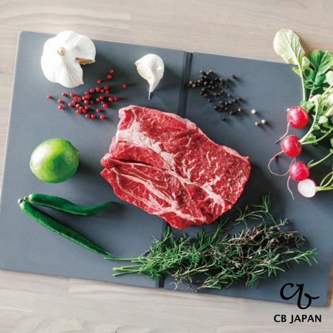CB JAPAN atomico 系列摺疊砧板，上面擺放著一塊生牛肉、大蒜、檸檬、辣椒、迷迭香、櫻桃蘿蔔和黑胡椒粒。