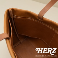 職人手作皮革托特包，棕褐色，展示內裡四個口袋的設計，縫線細緻。