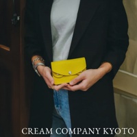 鮮黃色皮革手作零錢包，帶有銀色金屬釦，簡約設計，適合隨身攜帶。