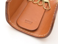 職人手作皮革經典鑰匙包，採用棕色皮革，配有四個金屬掛鉤，內側壓印有品牌標誌「HERZ MADE IN JAPAN」。