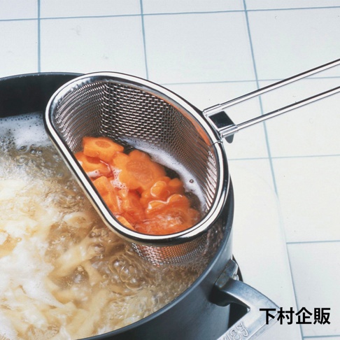 不鏽鋼可掛式料理濾網，網面細密，帶有兩個掛鉤和長柄，正懸掛在裝有滾水和切片胡蘿蔔的鍋中。