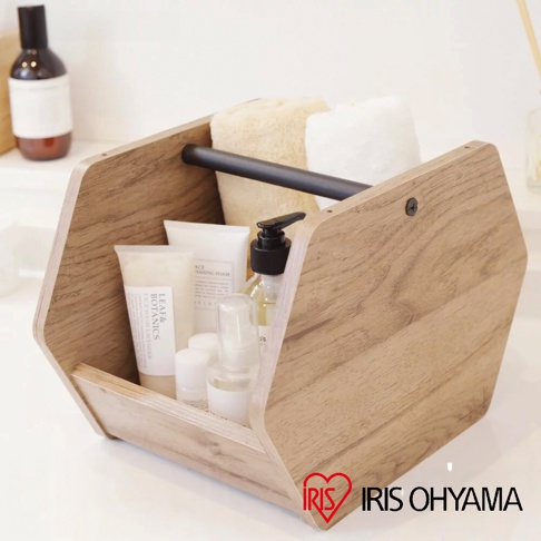 木質六邊形居家造型收納盒，內含乳白色毛巾、洗面乳、乳液、噴霧瓶及按壓瓶，提把為黑色金屬。