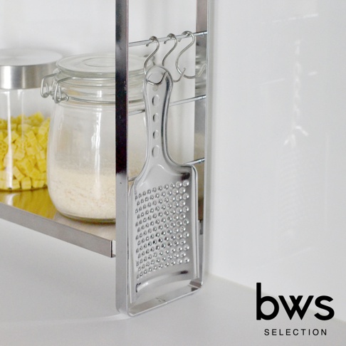 bws SELECTION 品牌標誌旁的廚房收納架上，懸掛著一個不鏽鋼刨絲器。