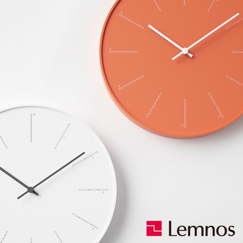 兩個圓形時鐘，一個為橘色，一個為白色。兩者皆為簡約設計，時標以白色線條呈現，並帶有獨特的間隔刻度。橘色時鐘的時針與分針為白色，白色時鐘的時針與分針為黑色。
