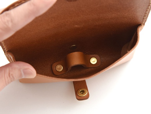 棕色皮革製眼鏡收納盒，內部有皮革固定帶和金屬釦，外部有磁吸釦。