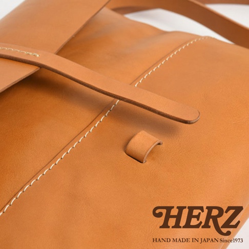 HERZ 職人手作皮革細扣帶馬鞍包 CK-3，近拍特寫，呈現棕色皮革材質與手工縫線的細節。