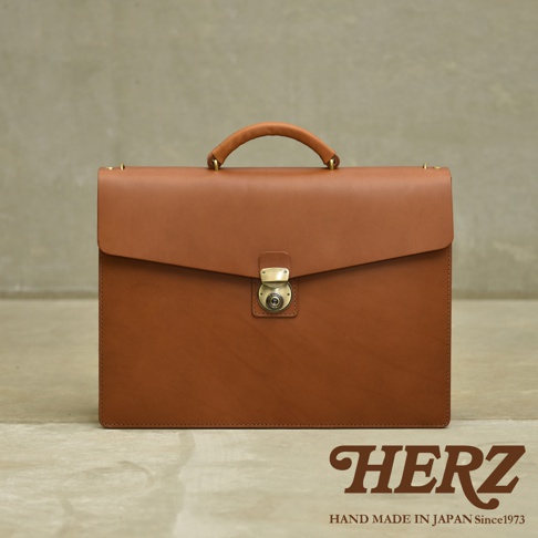 一款棕色皮革製成的公事包，配有提把和金屬旋轉鎖扣。