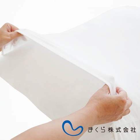 雙手正在套上純白色、觸感柔軟的無敵軟枕專用枕套，枕套材質平滑，邊緣有彈性。