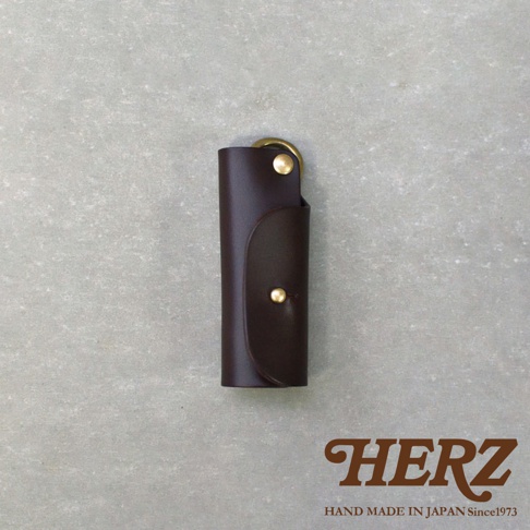 深棕色皮革製成的職人手作鑰匙套，帶有金色金屬扣和鑰匙圈。