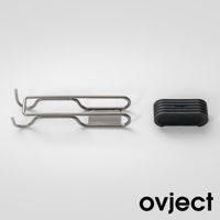 銀色金屬製雙用湯鍋支架，帶有掛勾設計，旁邊為黑色帶有溝槽的矽膠隔熱墊，墊上印有白色品牌標誌。