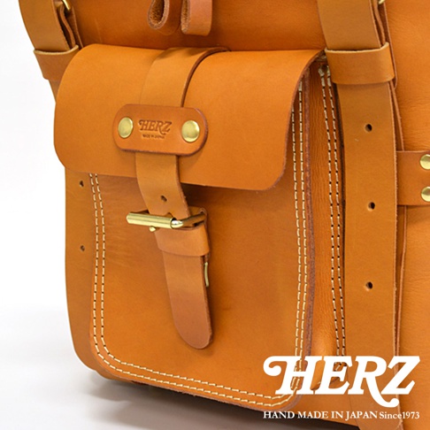 職人手作皮革大型三用旅行後背包，展示部分為焦糖棕色皮革，帶有明顯的縫線細節、皮帶扣和品牌標誌。