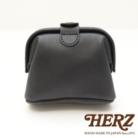 黑色皮革製成的手作口金化妝包，帶有金屬扣環，包身呈現醫藥包造型，底部和邊緣有明顯縫線。