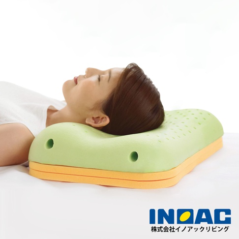 淺綠色記憶棉護頸枕，有雙層橙色底座，枕面帶有透氣孔。一名女子側臥，頭部枕在枕頭上，表情放鬆。