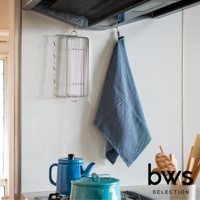 不鏽鋼折疊杯壺瀝水架，簡約銀色金屬材質，掛在廚房牆壁上，旁邊掛著藍色格紋抹布，下方擺放著藍色與綠色的茶壺。