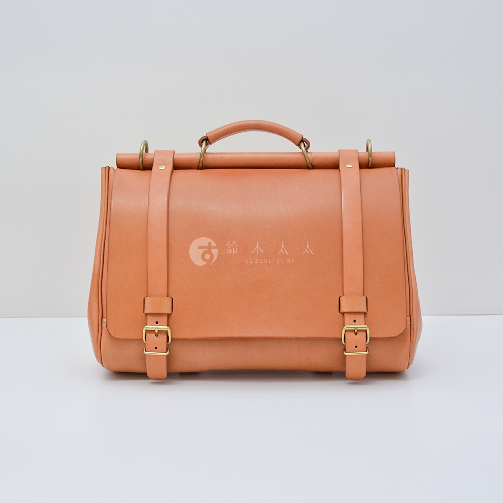 一個淺棕色的皮革公事包，帶有金色扣環和搭扣，以及一個頂部手柄。