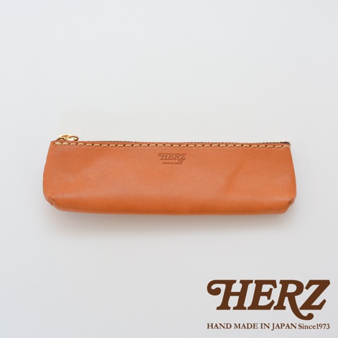 職人手作皮革經典收納筆袋，採用天然棕色皮革，配有金色拉鍊和縫線細節，呈現簡約復古風格。