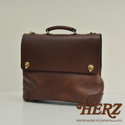 職人手作深棕色皮革旅行商務兩用波士頓包，附提把及金色旋轉鎖扣，風格簡約。